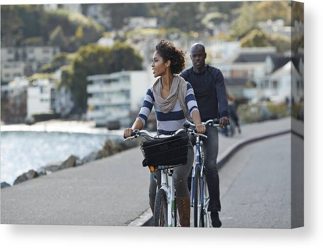 Water's Edge Canvas Print featuring the photograph Couple using rental bikes in the small town Sausalito by Klaus Vedfelt