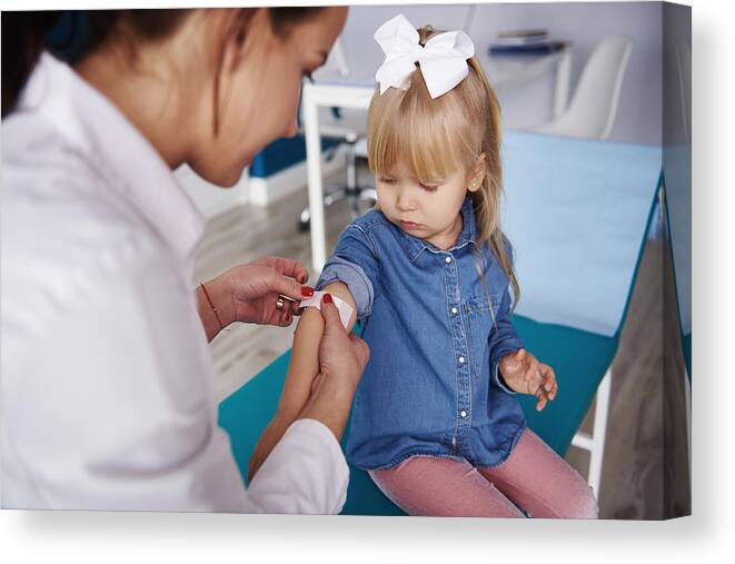 Expertise Canvas Print featuring the photograph Doctor applying band-aid on girl's arm in medical practice by Westend61