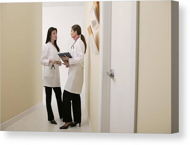 Mid Adult Women Canvas Print featuring the photograph Doctors talking in hallway by Comstock Images