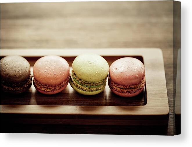 Unhealthy Eating Canvas Print featuring the photograph Four Macaroons Lined Up In A Narrow by Mmeemil