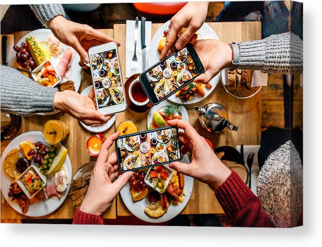 Breakfast Canvas Print featuring the photograph Friends taking pictures of food on the table with smartphones during brunch in restaurant by Alexander Spatari