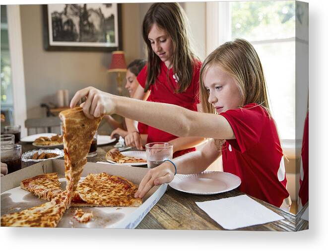 Soccer Uniform Canvas Print featuring the photograph Girls soccer team eating pizza by The Good Brigade