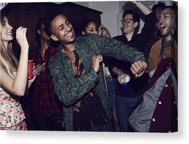 Young Men Canvas Print featuring the photograph Group of friends having fun at a party by Flashpop