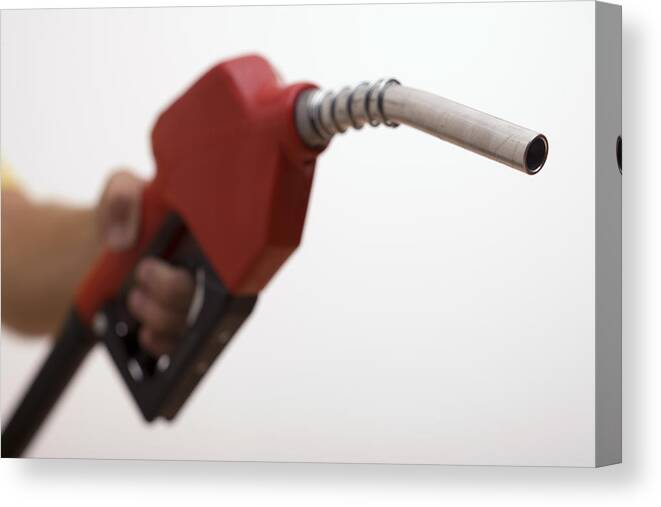 People Canvas Print featuring the photograph Hand holding a gas pump by Comstock Images