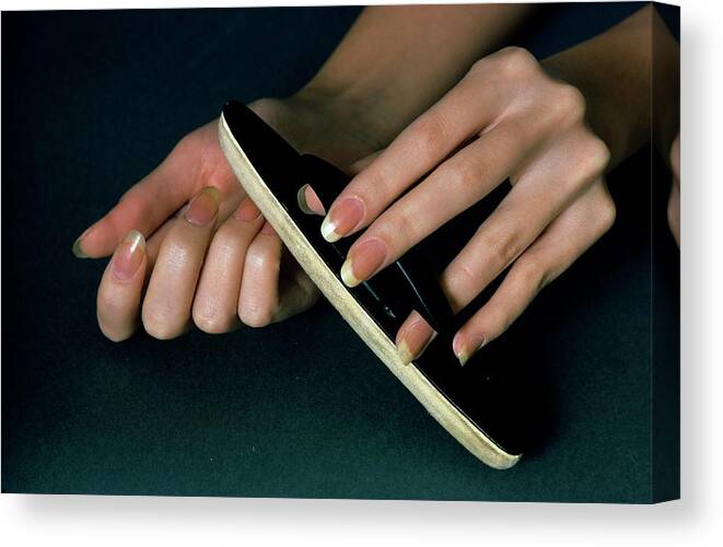 Beauty Canvas Print featuring the photograph Hands Of A Model Using A Nail Buffer by William Connors