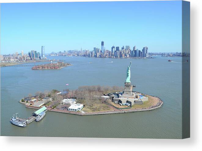 Ferry Canvas Print featuring the photograph Liberty And Ellis Island With Manhattan by Mrtom-uk