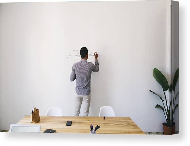 New Business Canvas Print featuring the photograph Man in office writing chart on wall by Westend61