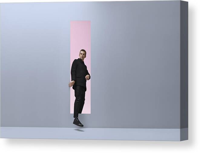 Rectangle Canvas Print featuring the photograph Man walking threw rectangular opening in coloured room by Klaus Vedfelt