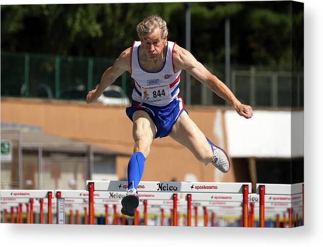 One Person Canvas Print featuring the photograph Masters British Athlete Clearing Hurdle by Alex Rotas