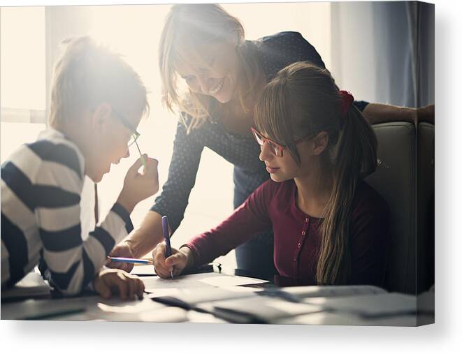 Education Canvas Print featuring the photograph Mother halping kids to do homework by Imgorthand