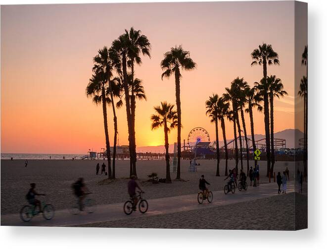 People Canvas Print featuring the photograph People ride bikes and walk along the beach at sunset in Santa Monica, California. by Brian Eden