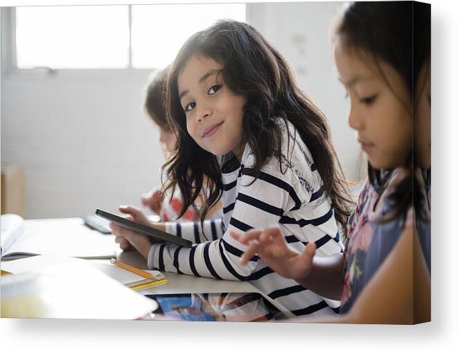 Internet Canvas Print featuring the photograph Portrait of smiling girl using digital tablet in classroom by JGI/Jamie Grill