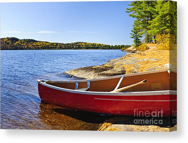 Canoe Canvas Print featuring the photograph Red canoe on shore by Elena Elisseeva