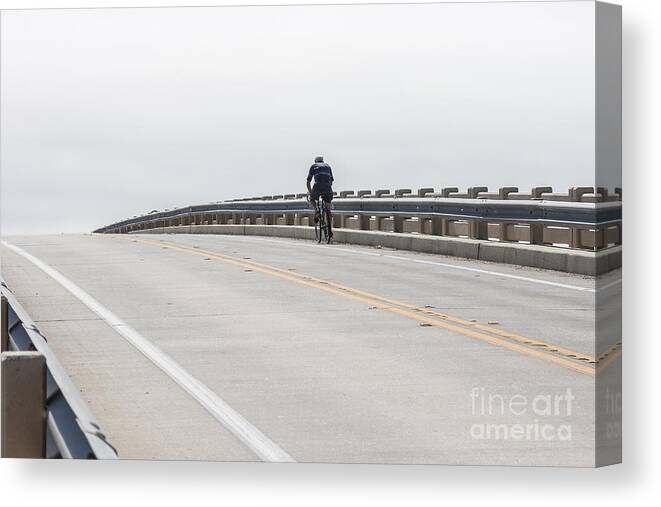 Cyclist Canvas Print featuring the photograph A Cyclist Rides over a Bridge into the Horizon by William Kuta