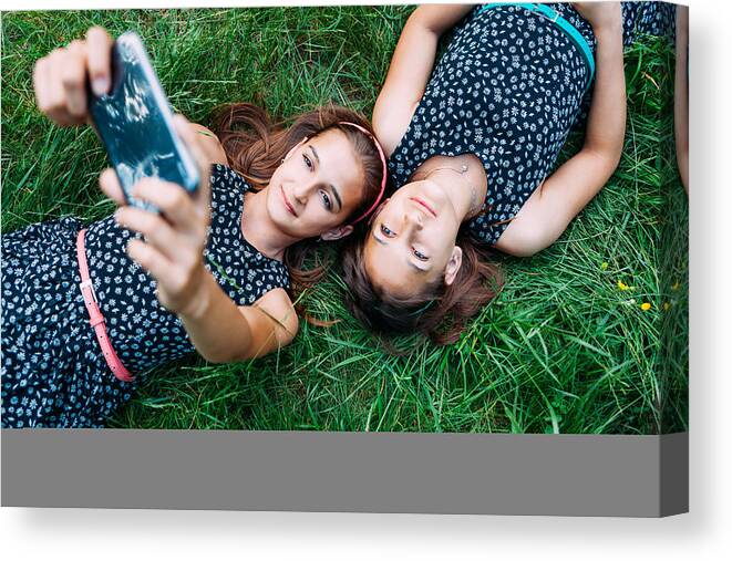 Grass Canvas Print featuring the photograph Sisters making a selfie by Martin-dm