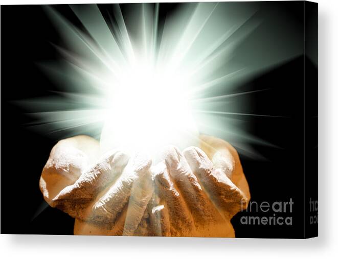 Spiritual Canvas Print featuring the photograph Spiritual light in cupped hands on a black background by Simon Bratt