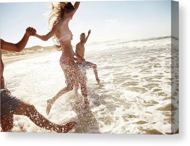 Young Men Canvas Print featuring the photograph Splashing Through The Waves by Pixdeluxe