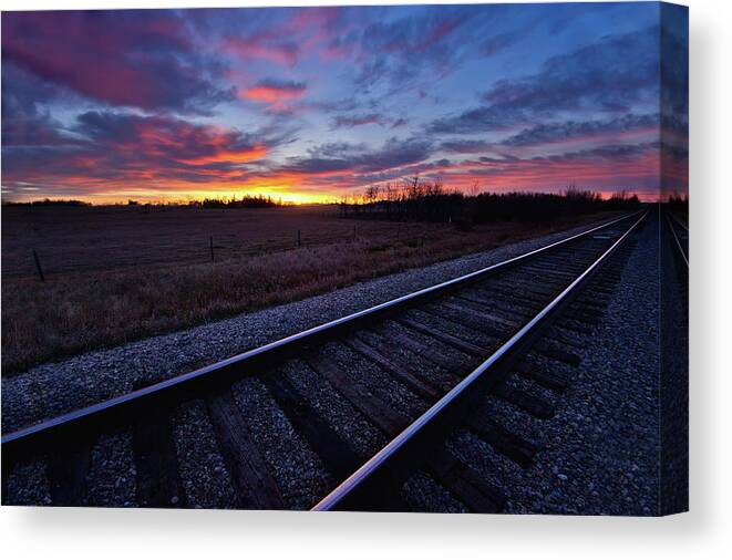 Rail Transportation Canvas Print featuring the photograph Train Tracks And A Dramatic Colourful by John Kroetch / Design Pics
