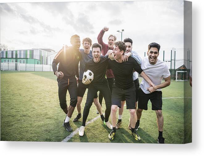 Young Men Canvas Print featuring the photograph Winning football team cheering by JohnnyGreig