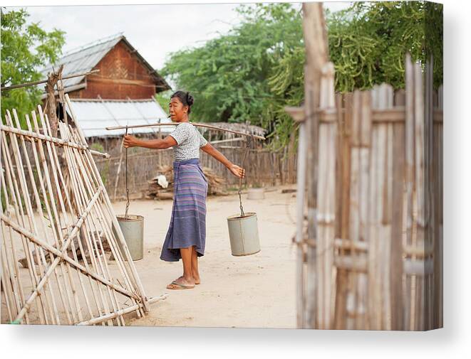 Pole Canvas Print featuring the photograph Woman Carrying Buckets With Pole Across by Cultura Rm Exclusive/yellowdog