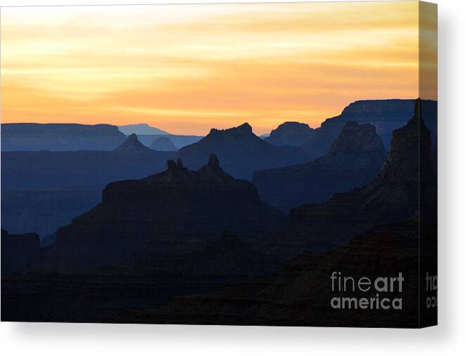 Travelpixpro Grand Canyon Canvas Print featuring the photograph Yellow Orange Sunset Twilight over Silhouetted Spires in Grand Canyon National Park by Shawn O'Brien