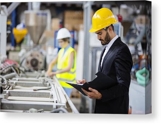 Expertise Canvas Print featuring the photograph Young quality inspector checking production line by Milanvirijevic