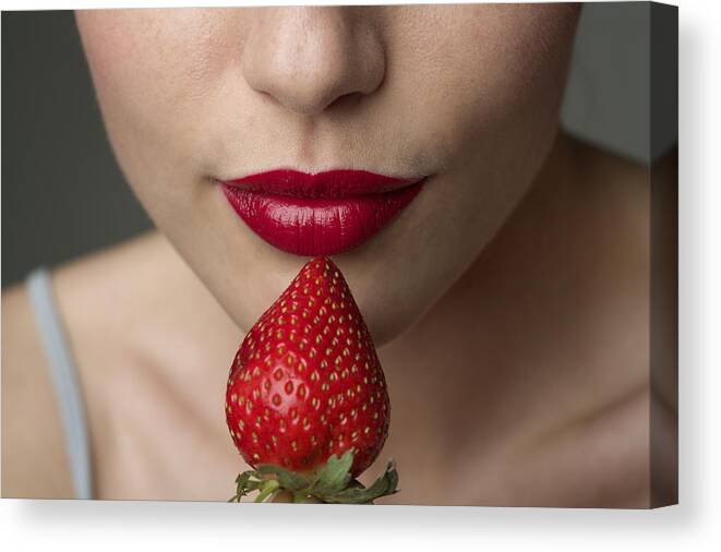 People Canvas Print featuring the photograph Young woman with red lips eating a strawberry (part of), close-up by Stock4b-rf