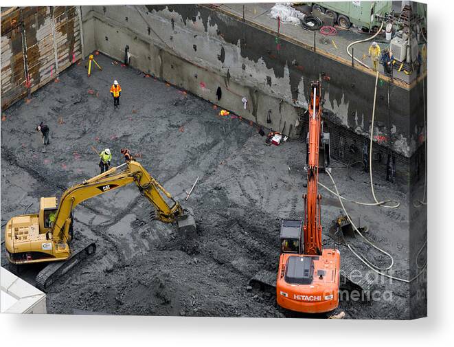 Construction Canvas Print featuring the photograph CONSTRUCTION SITE diggers and workmen in the foundation pit of a new building Seattle by Andy Smy
