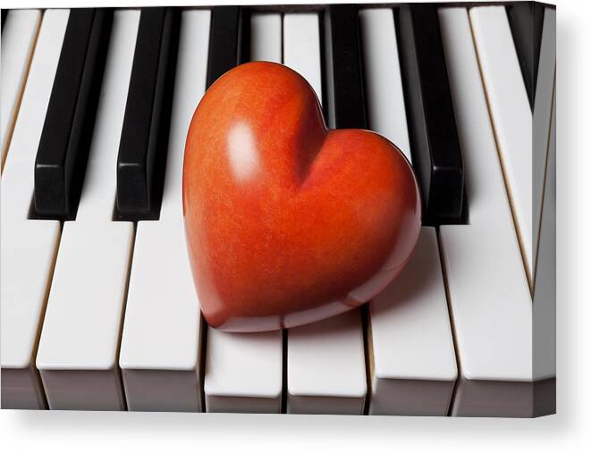 Red Canvas Print featuring the photograph Red stone heart on piano keys by Garry Gay