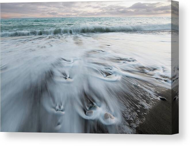 Coastline Canvas Print featuring the photograph Pebbles in the beach and flowing sea water by Michalakis Ppalis