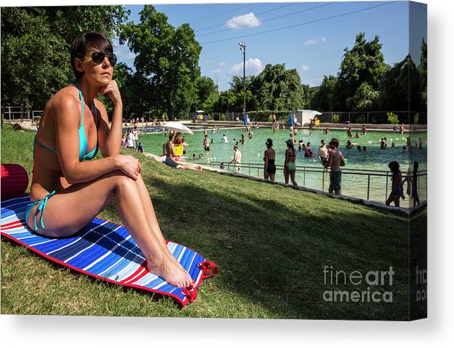 Deep Eddy Pool Canvas Print featuring the photograph A fit Austin woman sunbathes in a bikini at Deep Eddy Pool, surrounded by grassy slopes which are the best in Austin for sunbathing by Dan Herron