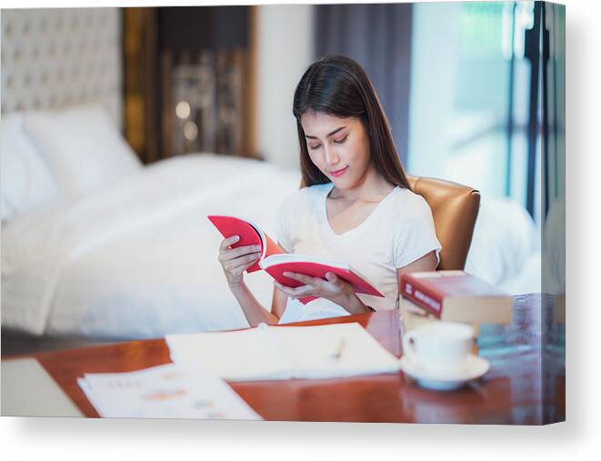 Book Canvas Print featuring the photograph Asian lady student read a text book for prepare to examination o by Anek Suwannaphoom