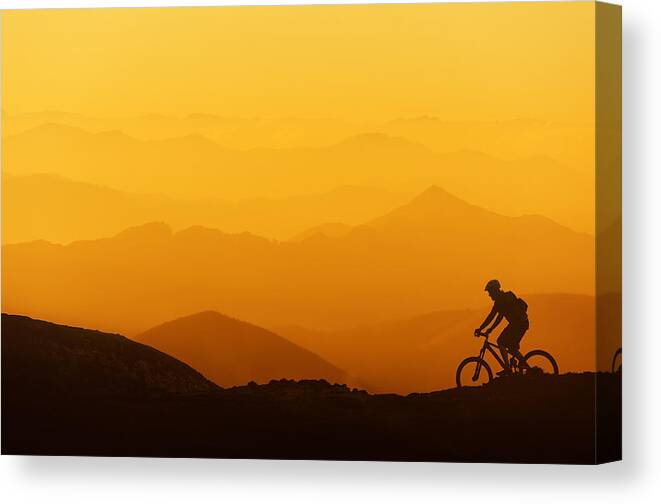 Biker Canvas Print featuring the photograph Biker Riding On Mountain Silhouettes Background by Mikel Martinez de Osaba