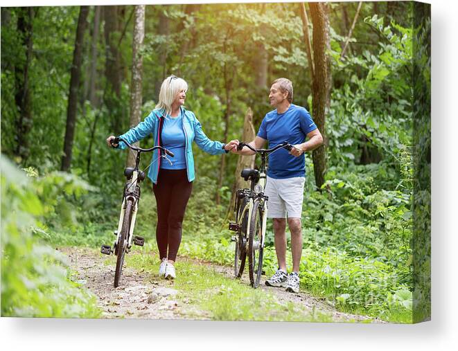 Man Canvas Print featuring the photograph Elderly marriage with bicycles holding hands by Michal Bednarek