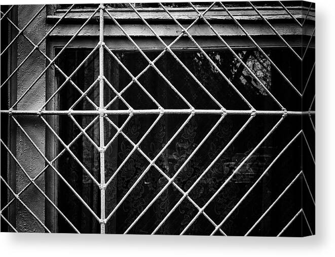 Wall Art Canvas Print featuring the photograph Metal Spider Web Windowframe in Monochrome by John Williams