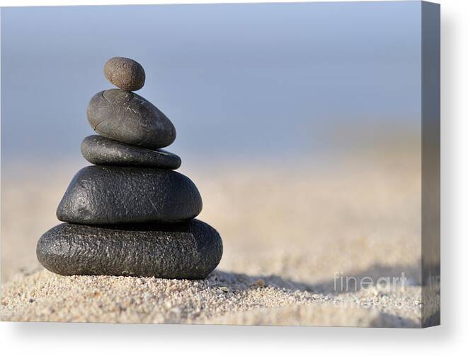 Order Canvas Print featuring the photograph Stack of black pebbles on beach by Sami Sarkis