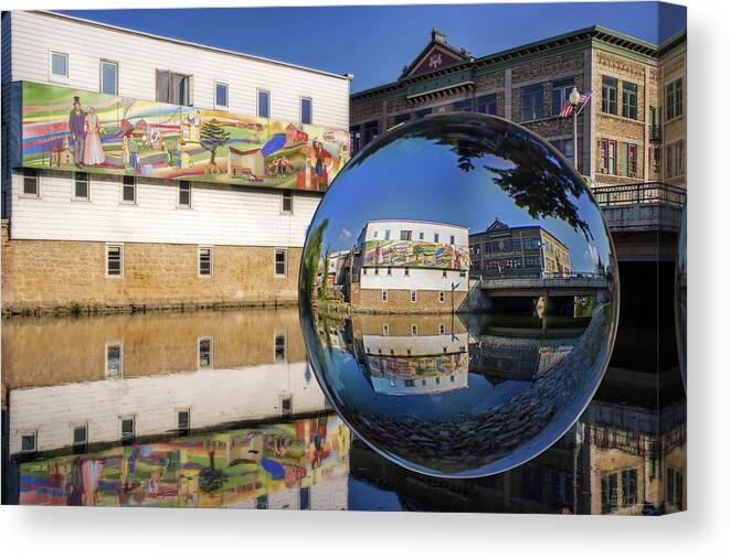 Stoughton Wi Wisconson Mural Yahara River Glass Sphere Water Horizontal Buildings Canvas Print featuring the photograph Stoughton Downtown Mural on Yahara River by Peter Herman