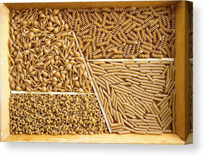 Assorted Canvas Print featuring the photograph Wooden tray with assorted whole wheat pasta by Karen Foley