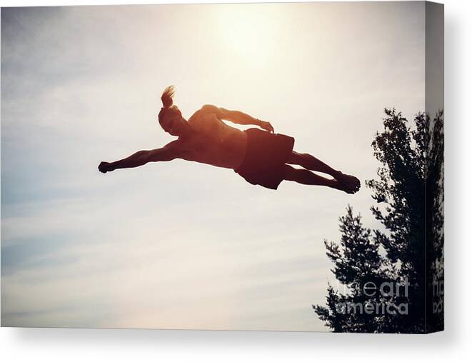 Man Canvas Print featuring the photograph Young man levitating in the air. by Michal Bednarek