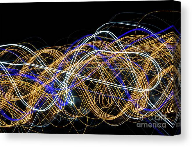Abstract Canvas Print featuring the photograph Colorful light painting with circular shapes and abstract black background. #1 by Joaquin Corbalan