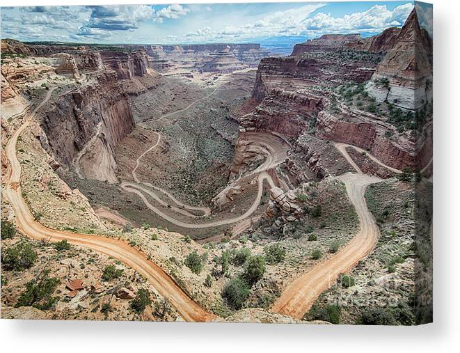 Southwest Canvas Print featuring the photograph A 4wd Vehicle Makes Its Way Down A Dirt by Steve Lagreca