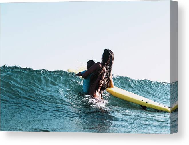 Portrait Canvas Print featuring the photograph A Surfer Mother Surfing With Her Son by Cavan Images