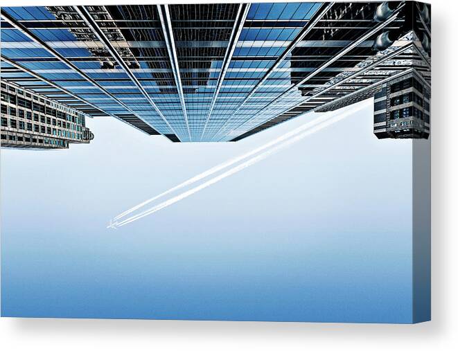 Clear Sky Canvas Print featuring the photograph Aeroplane And Skyscrapers From Below by Caroline Purser