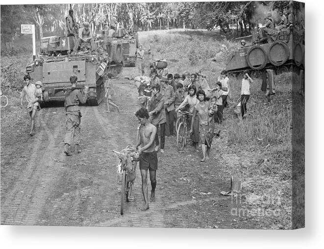 Vietnam War Canvas Print featuring the photograph Army Tank & Group Of Cambodian Refugees by Bettmann