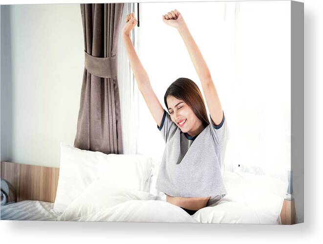 Woman Canvas Print featuring the photograph Asian lady in wake up action in the bed room by Anek Suwannaphoom