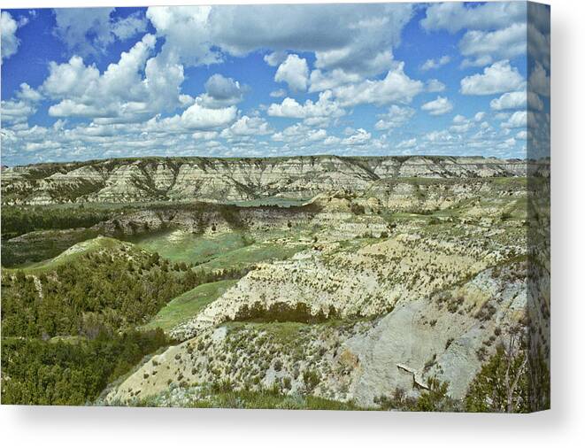 Scenics Canvas Print featuring the photograph Cloud Formation Over A Badland Canyon by Jeffgoulden