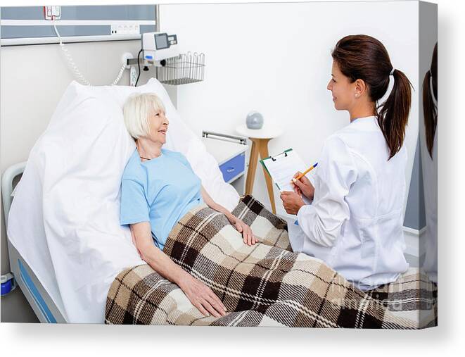 Doctor Canvas Print featuring the photograph Doctor Talking To Senior Woman On Hospital Ward by Peakstock / Science Photo Library