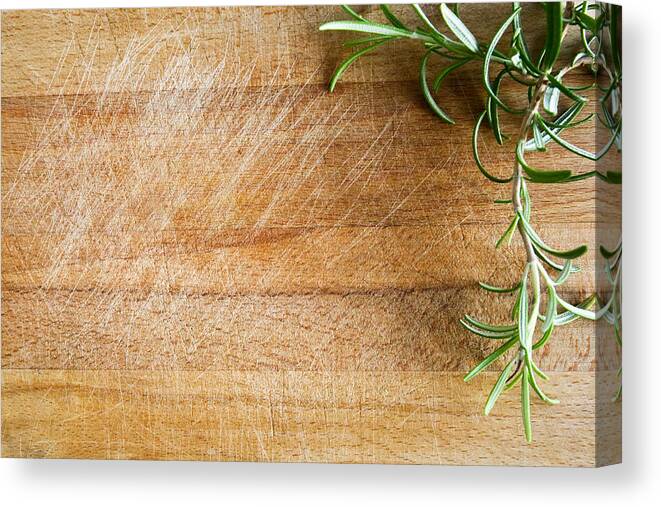 Holiday Canvas Print featuring the photograph Fresh Rosemary On A Wood Chopping Board by Infrontphoto