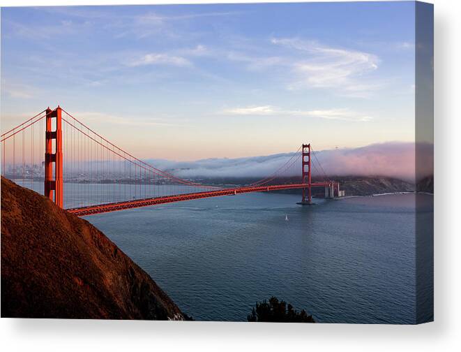 Built Structure Canvas Print featuring the photograph Golden Gate Bridge At Sunset With Fog by Billnoll