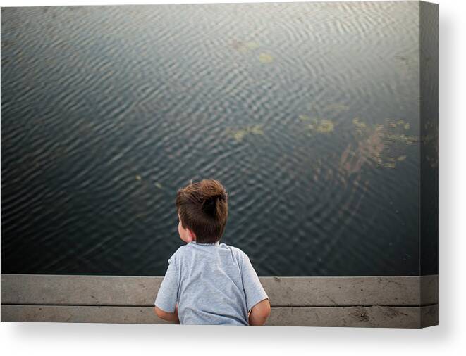 Boy Canvas Print featuring the photograph High Angle View Of Boy Lying On Pier Over Lake At Park by Cavan Images